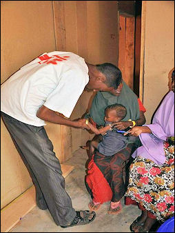 20120514-MSF_health_worker_examines_a_malnourished child.jpg